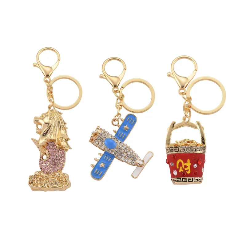 3er-Set emaillierte weiße und mehrfarbige Kristall-Schlüsselanhänger mit Merlion, Flugzeug und rotem Eimer, Legierung in Gelbgold