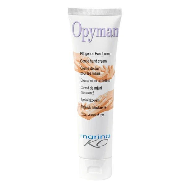 Eine weiße Stehtube der Kiehl Opyman Pflegende Handcreme (100 ml) der Johannes Kiehl KG mit Handabbildung und mehrsprachigem Text sorgt für intensive Feuchtigkeit; auf dem Boden ist "marina KC" aufgedruckt.